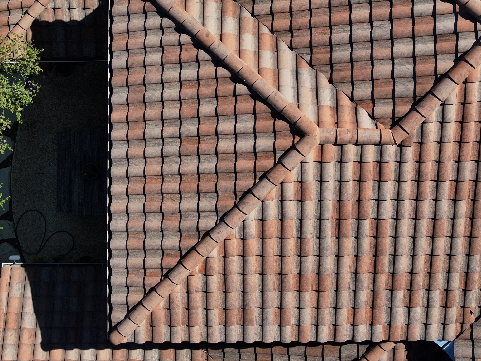 Aerial close-up of repaired tile field and ridge transition on Boerne roof