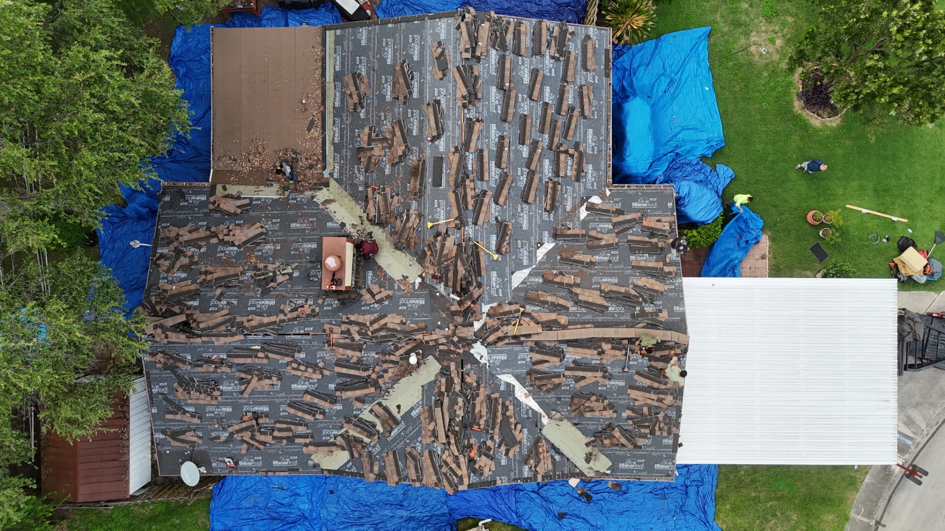 Tear-off in progress — old shingles stripped down to the underlayment on a San Antonio roof