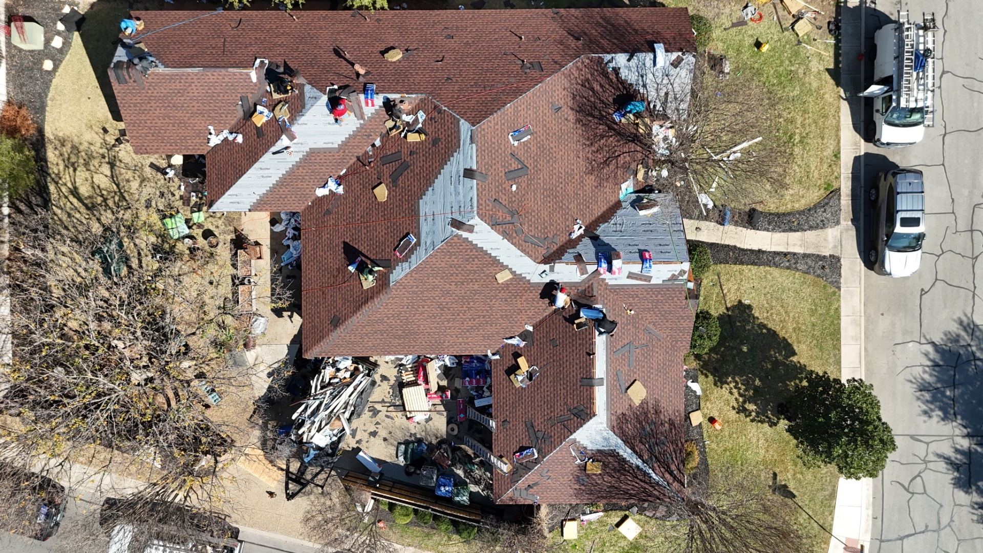 Top-down drone photo of Helotes roof with most shingles installed and crew finishing details