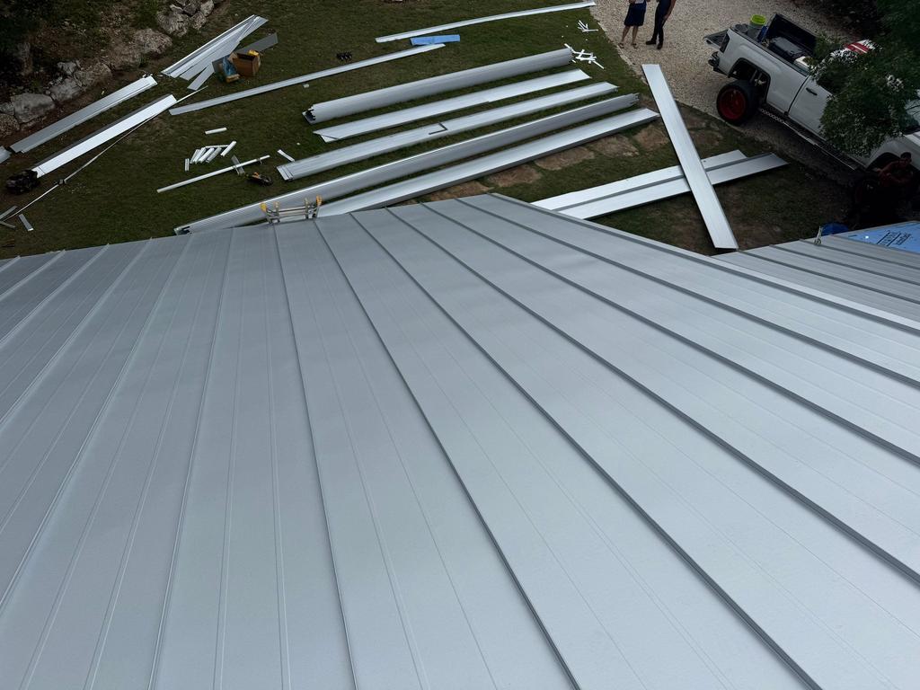 Freshly installed standing seam panels with material staged below