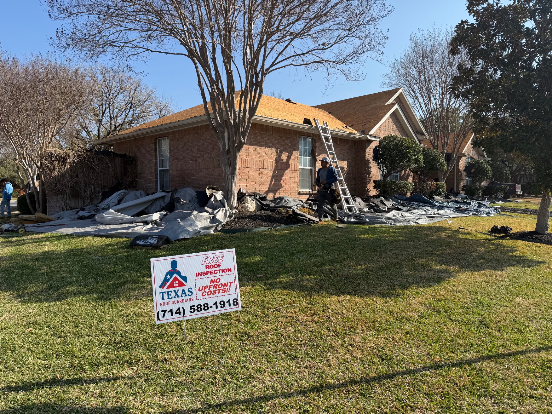 Ground-level view of Helotes roof tear-off and decking prep with crew on site