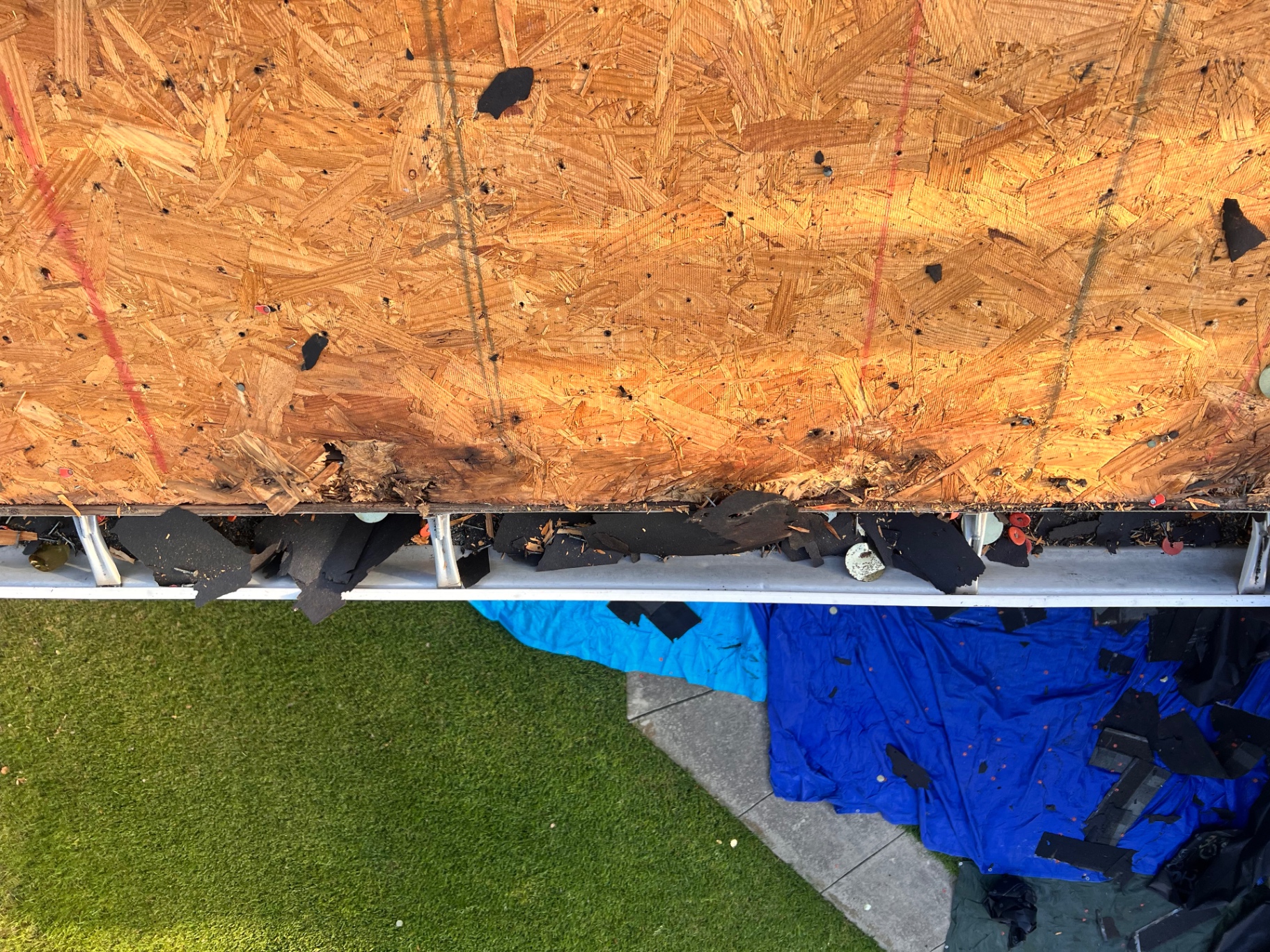 Wide view of damaged roof decking along the eave during Braun Station roof replacement
