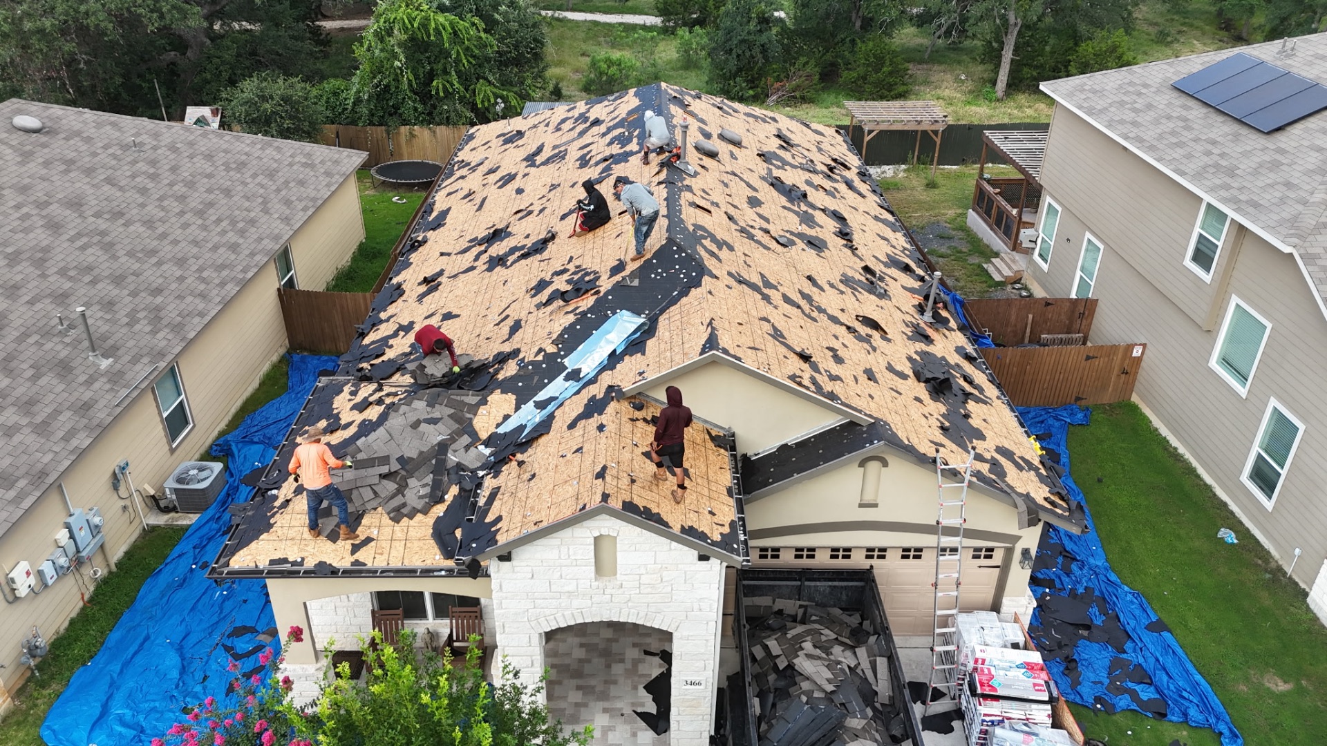 Tear-off in progress — crew stripping shingles down to the decking in Copper Canyon, Bulverde
