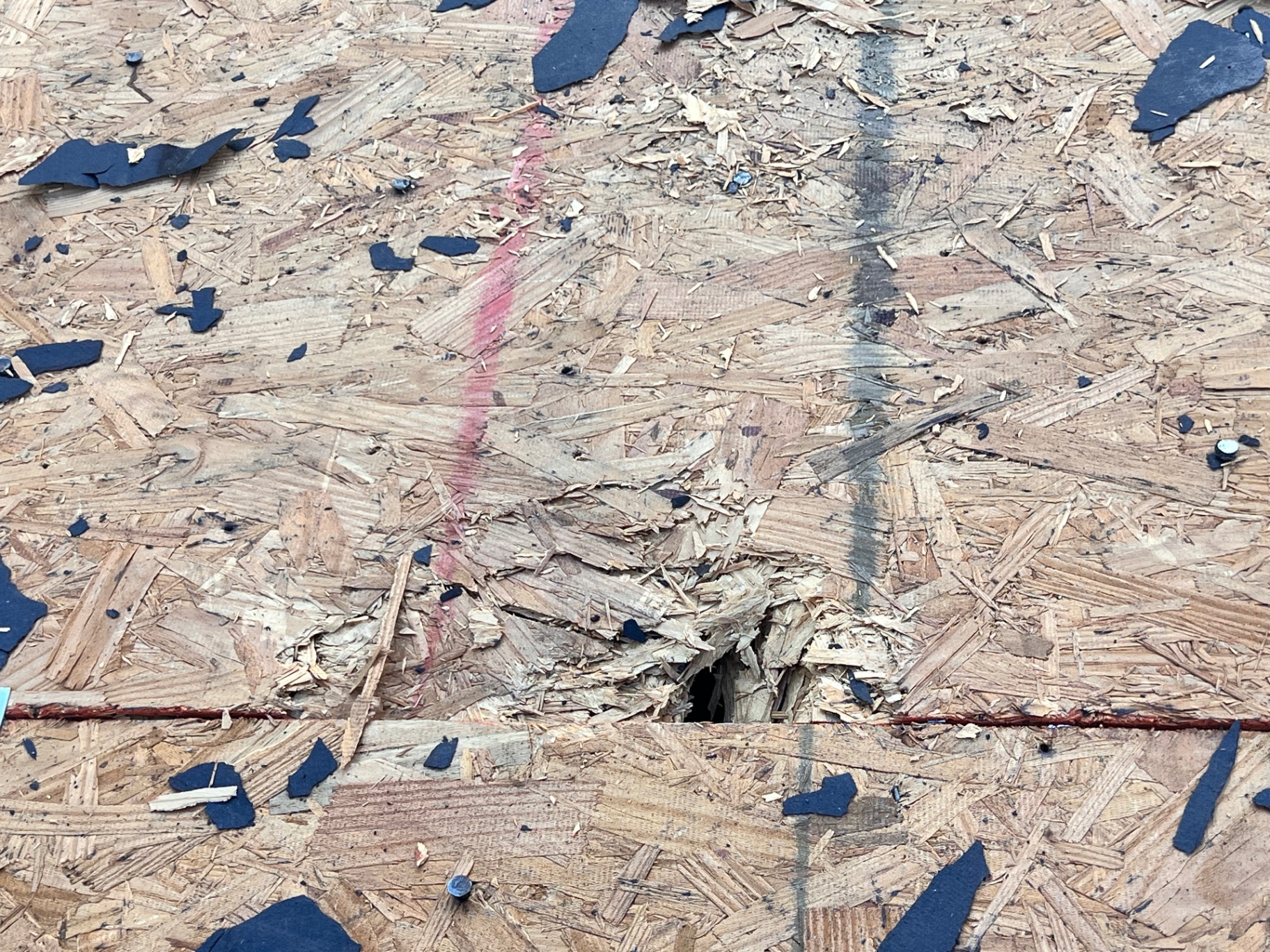 Open hole in roof decking uncovered during Braun Station tear-off before new GAF Timberline HDZ shingles were installed