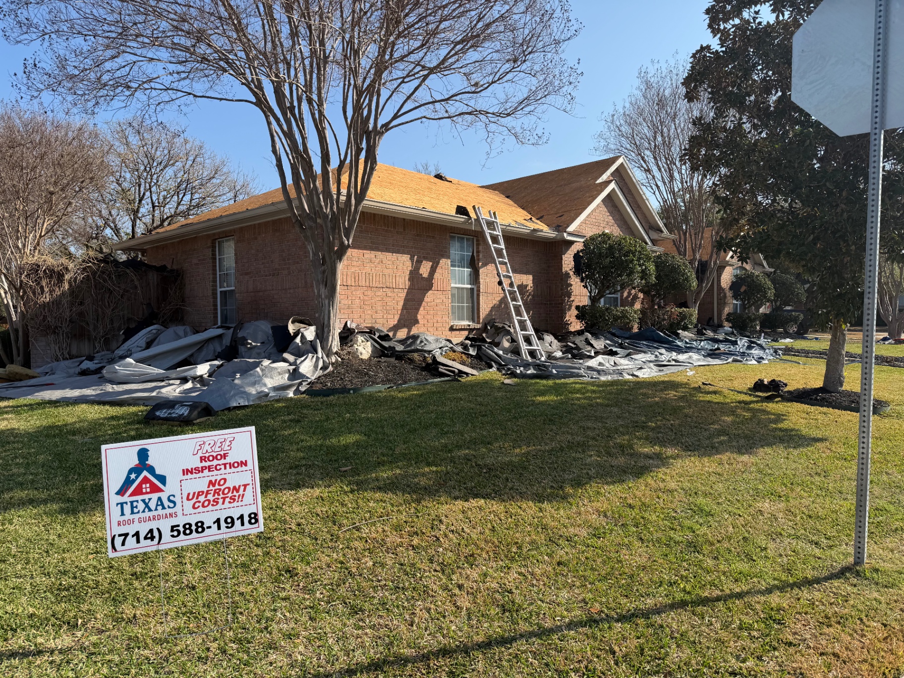 Street-side progress photo of Helotes roof replacement during tear-off and prep