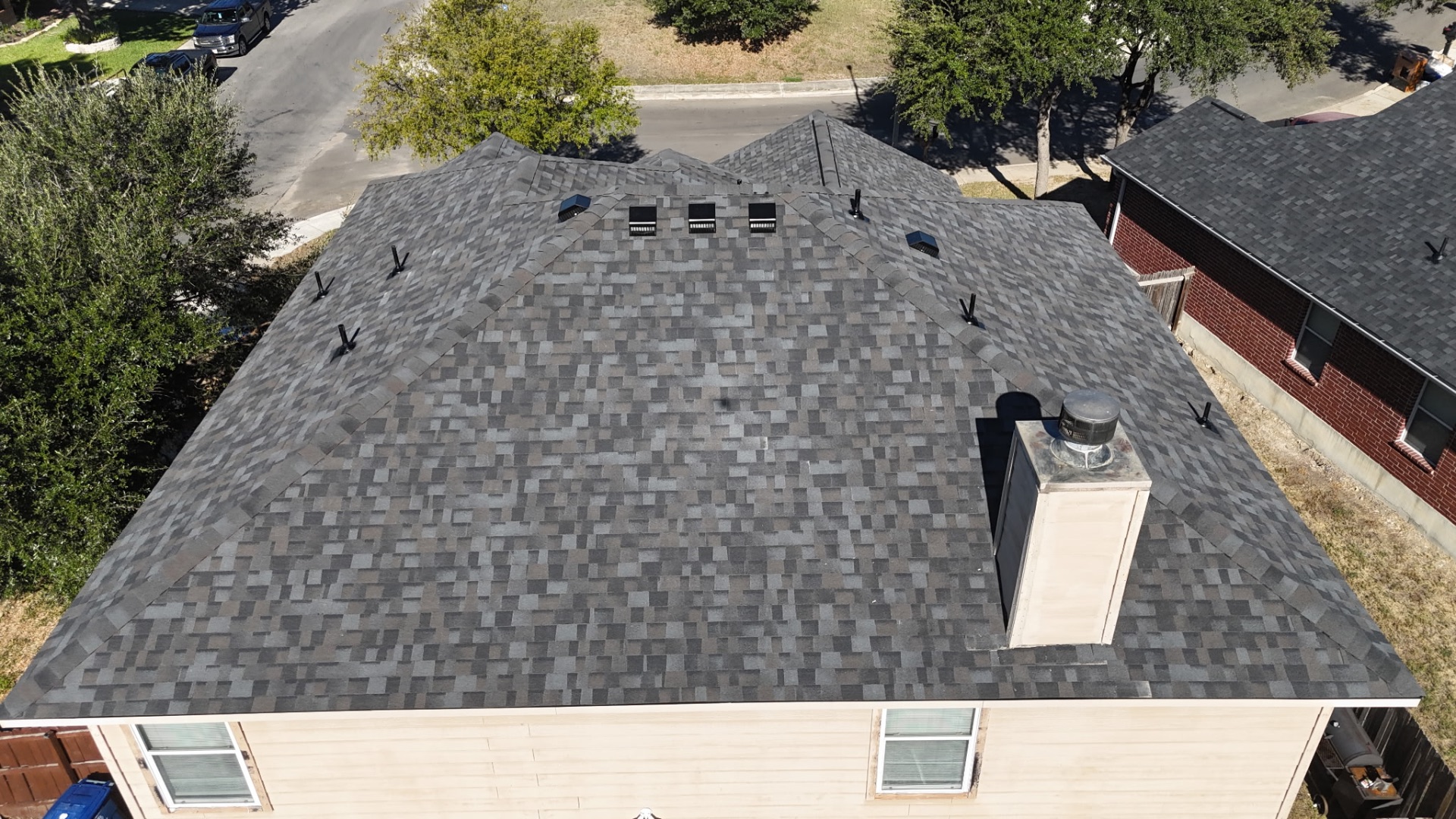 Rear ridge-level aerial of finished Stone Oak shingle roof with ventilation details