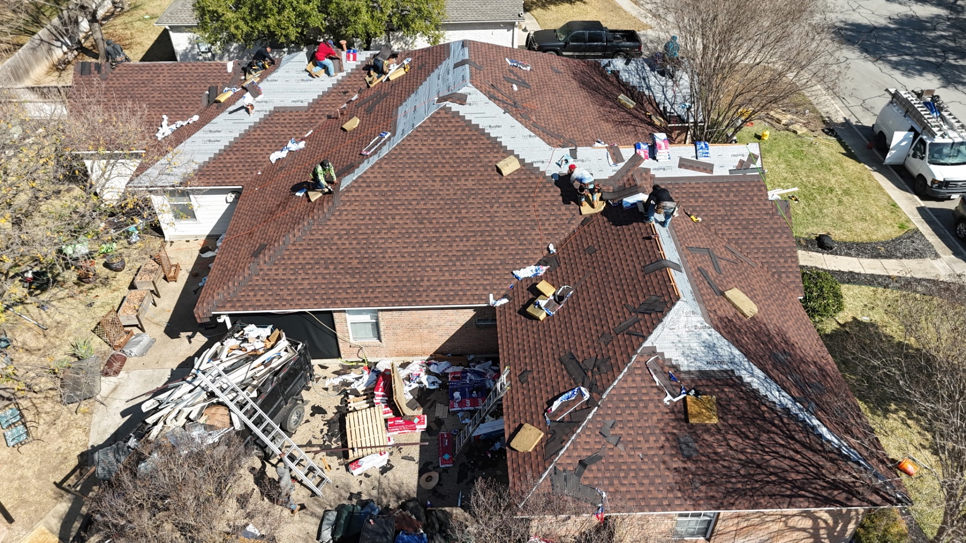 Angled aerial of Helotes roof nearing completion with deep multi-tonal shingles installed