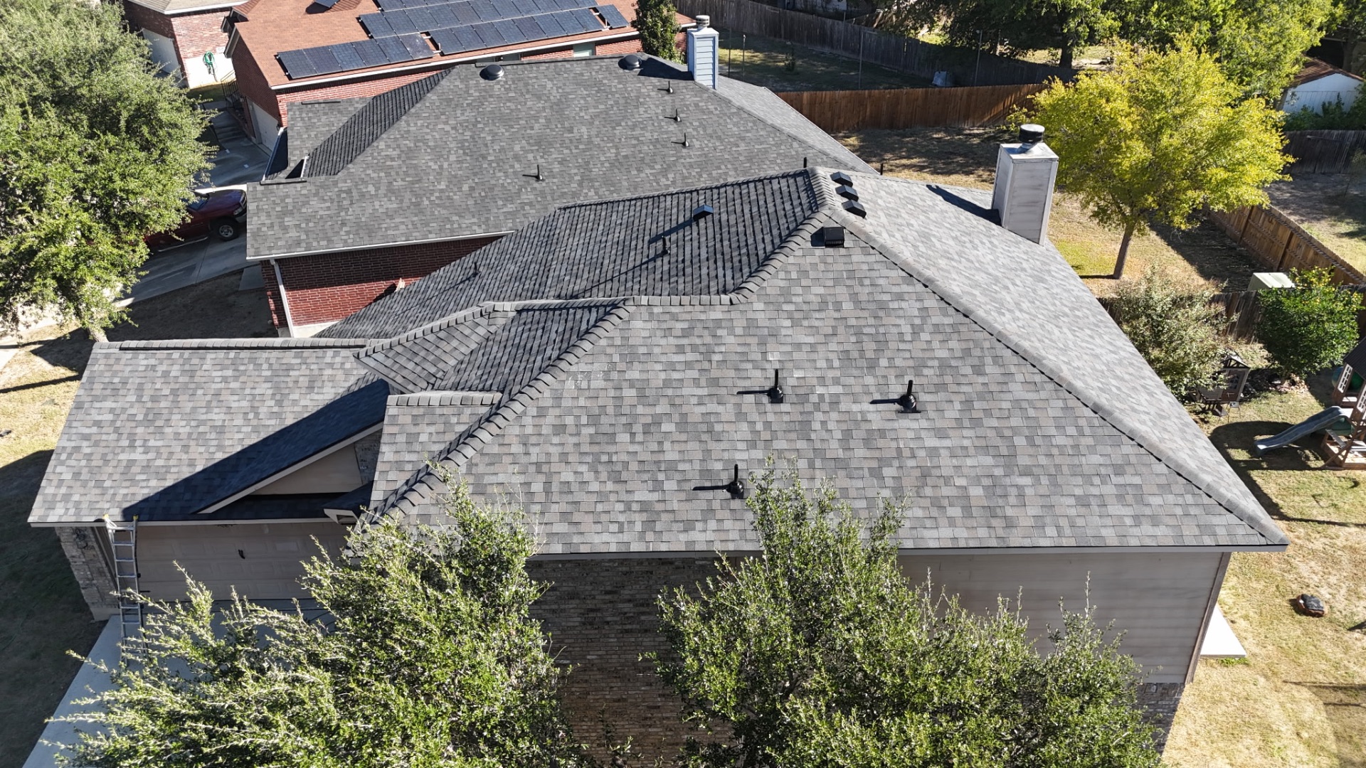 Rear aerial showing completed roof replacement on Stone Oak home