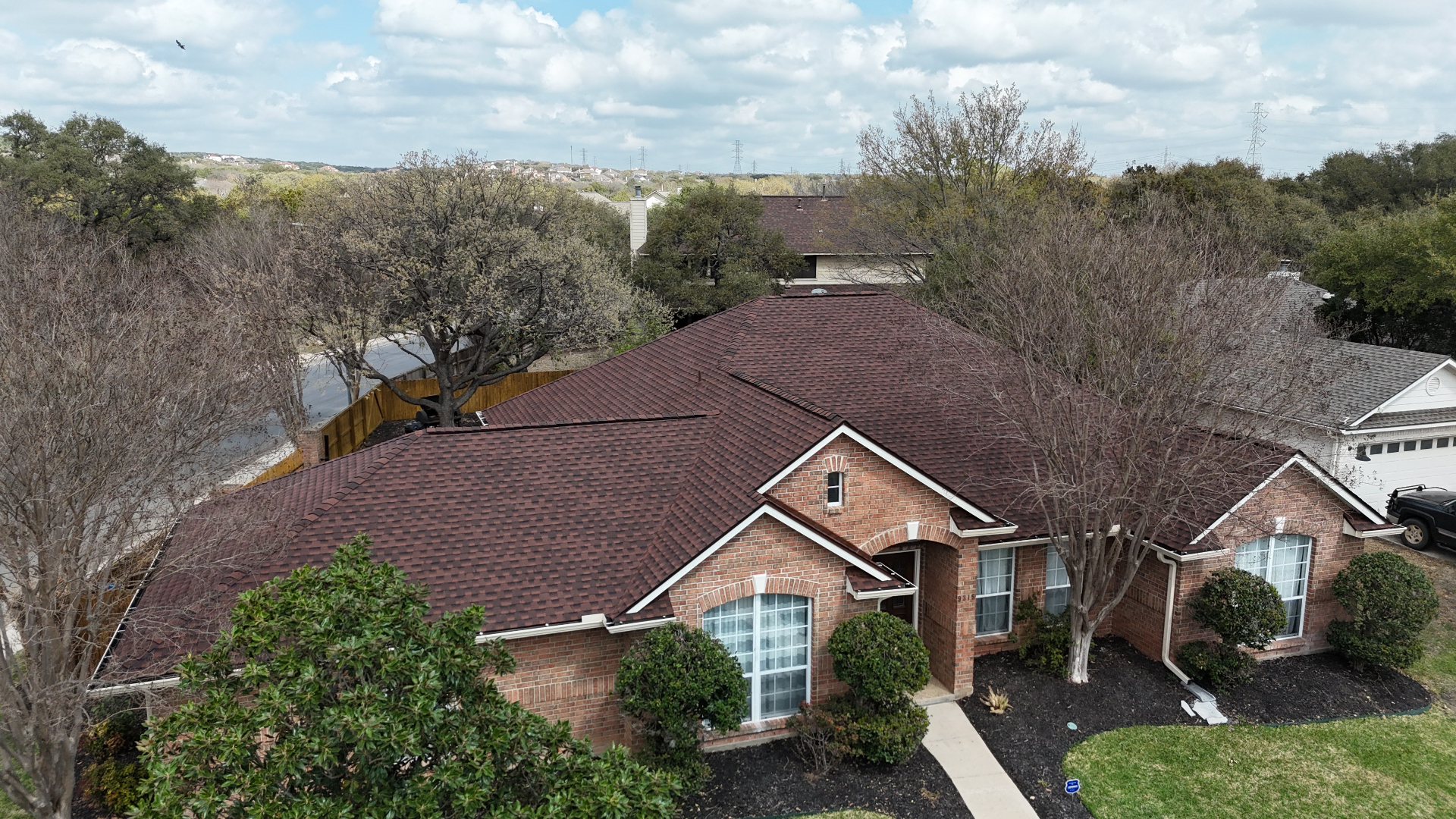 Aerial front view of completed Helotes architectural shingle roof on brick home