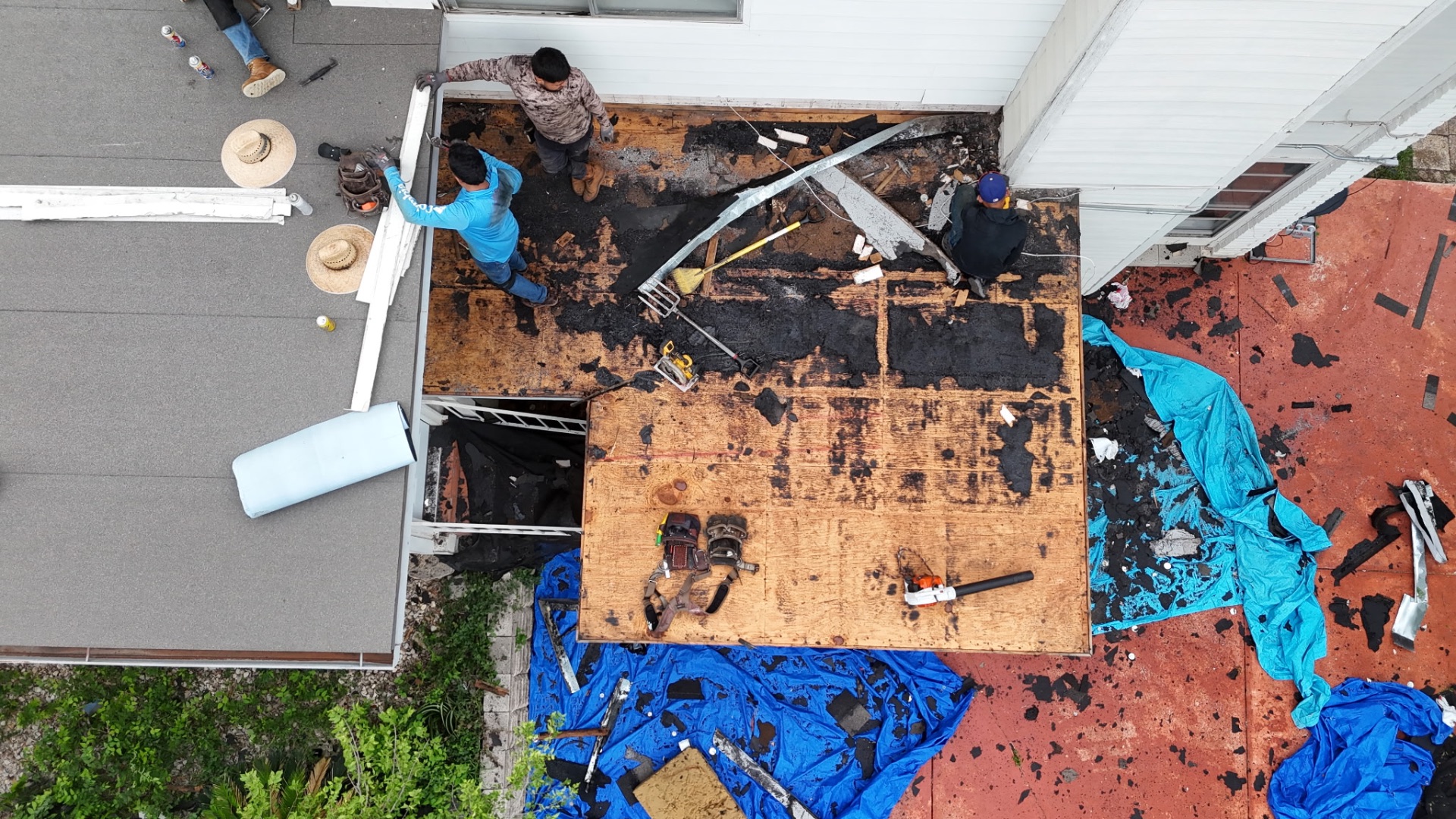 Crew tearing off old roof and exposing rotted decking at rear addition in San Antonio