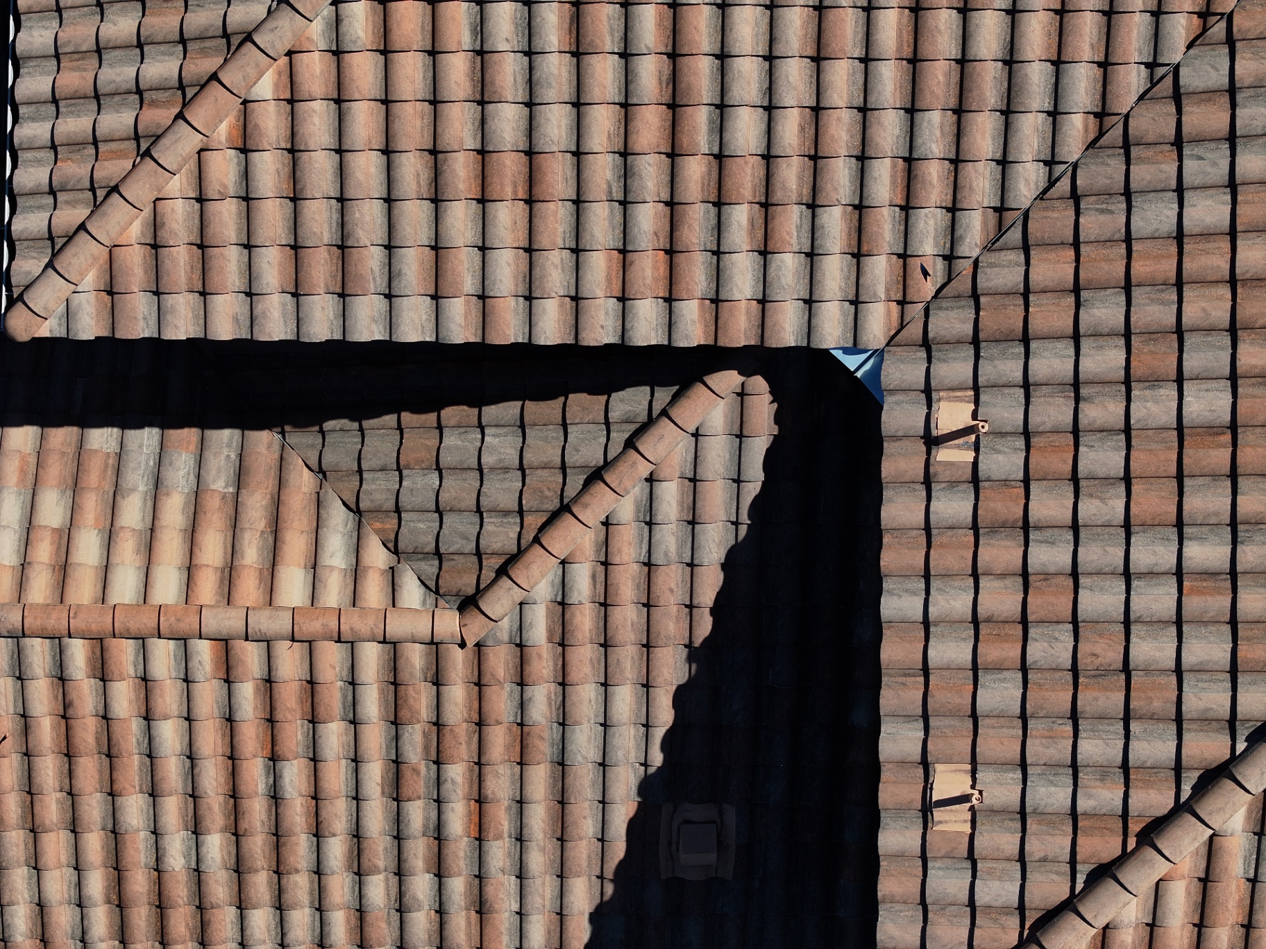 Drone view showing multiple repaired tile areas integrated across the Boerne roof