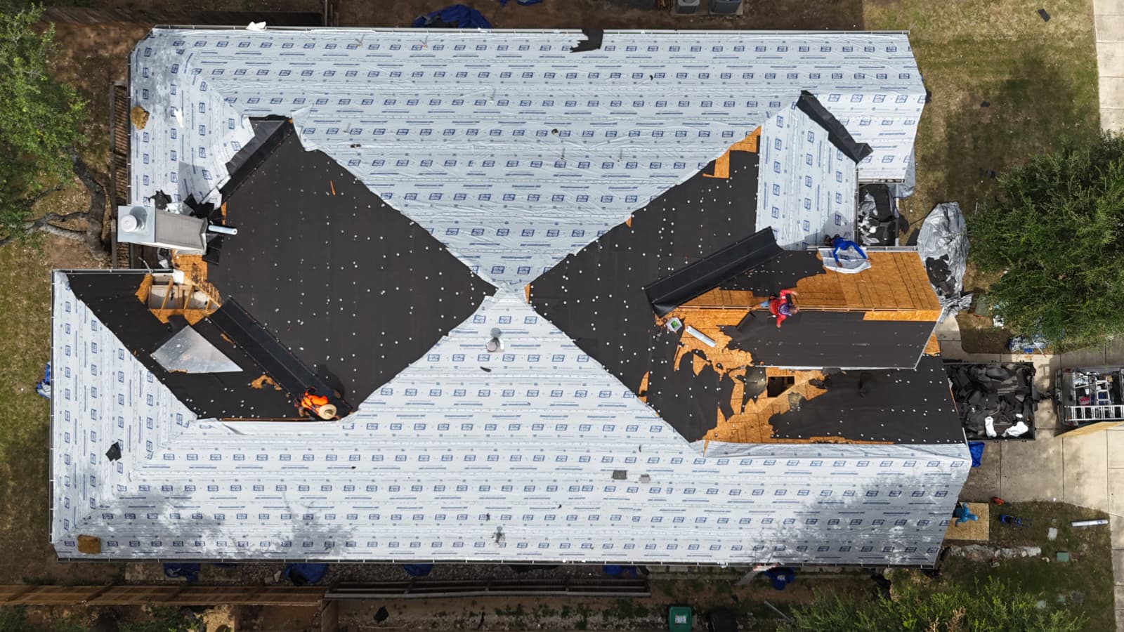 Top-down drone view of San Antonio roof during dry-in with synthetic underlayment installed