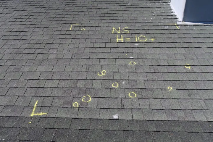Roofing inspector documenting hail damage on a Central Texas home